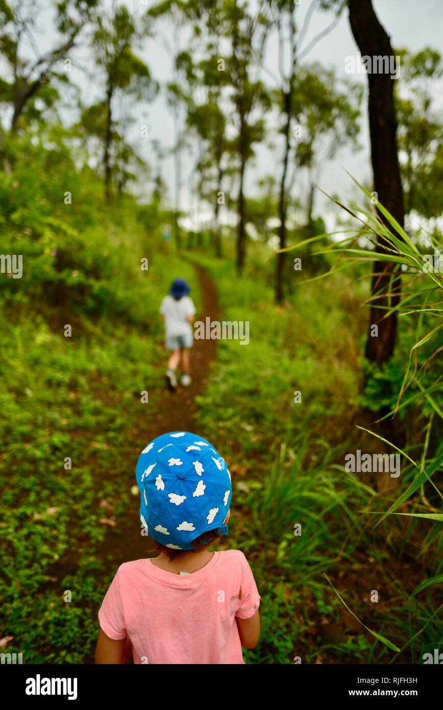 Junge Kinder im Schulalter entlang einem Feldweg, Moongun Wanderweg am Elliot Federn, Townsville, Queensland, Australien Stockfoto