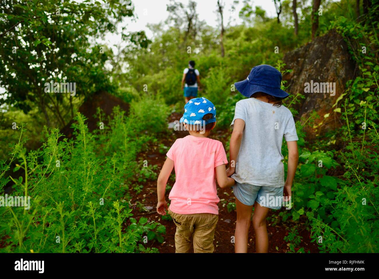 Junge Kinder im Schulalter entlang einem Feldweg, Moongun Wanderweg am Elliot Federn, Townsville, Queensland, Australien Stockfoto