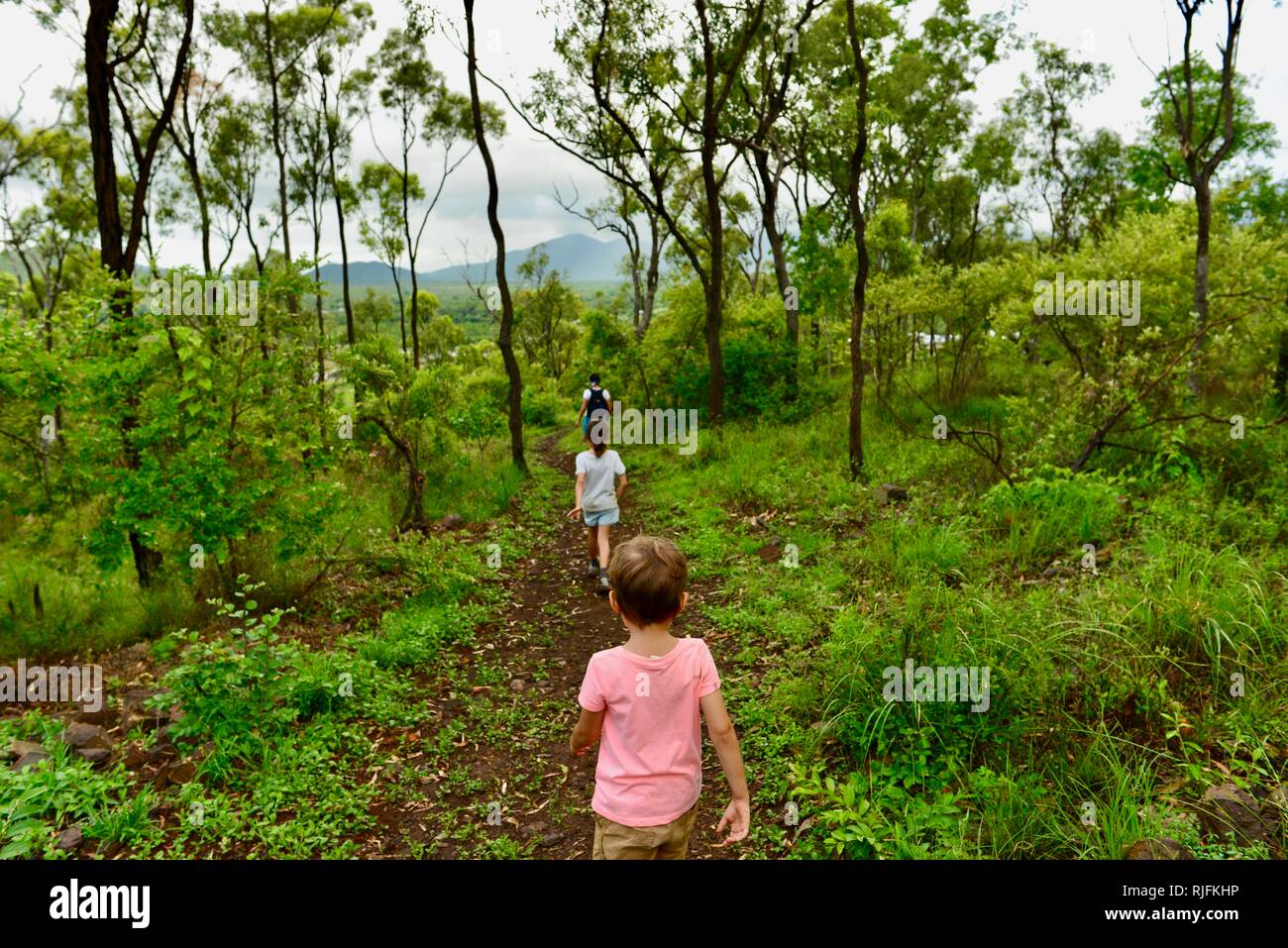 Junge Kinder im Schulalter entlang einem Feldweg, Moongun Wanderweg am Elliot Federn, Townsville, Queensland, Australien Stockfoto