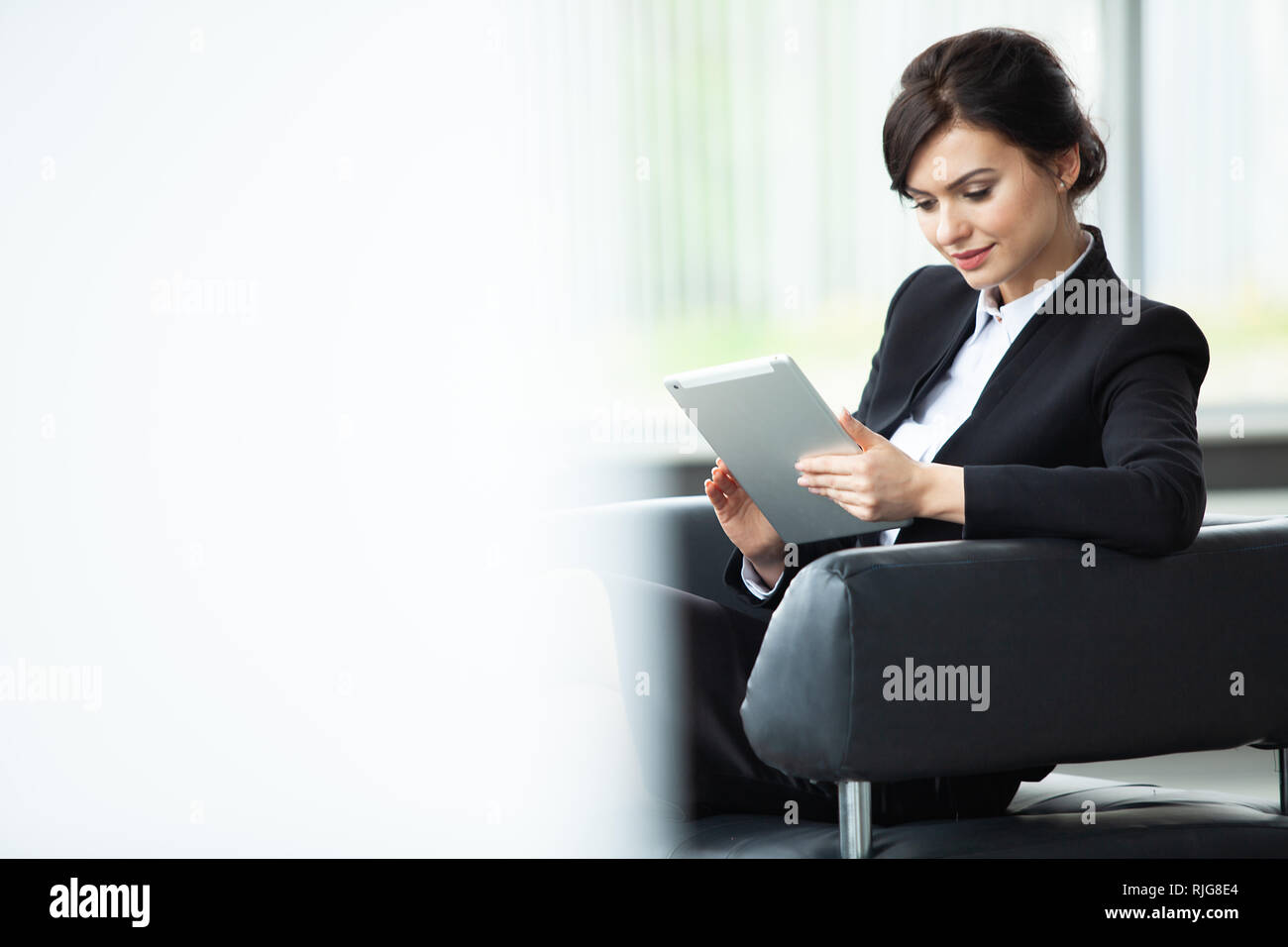 Stilvolle Geschäftsfrau, sitzen auf einem Sofa mit Tablet-PC im Büro. Stockfoto