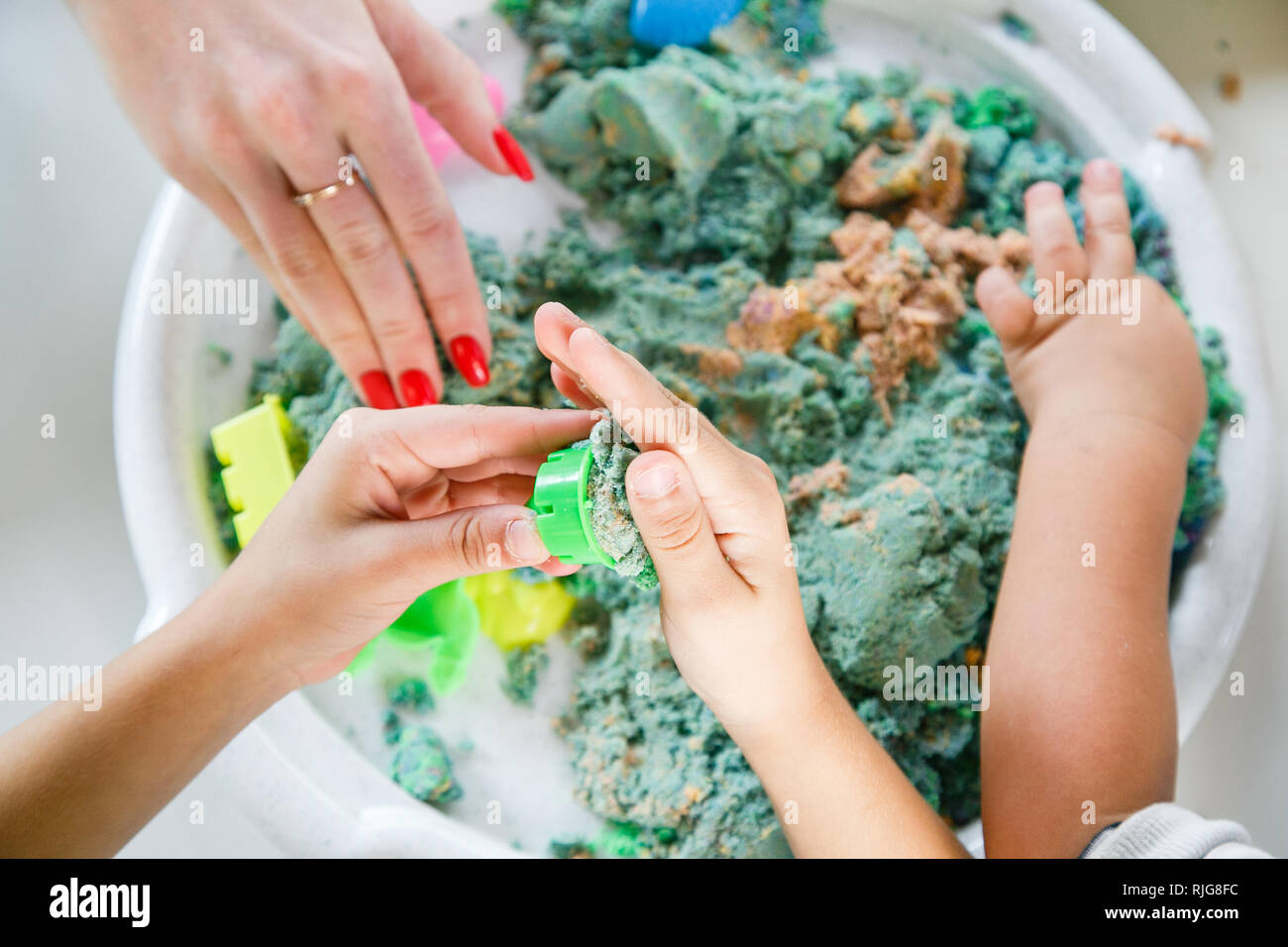 Die Hände eines Kindes spielen mit kinetischen Sand Stockfoto