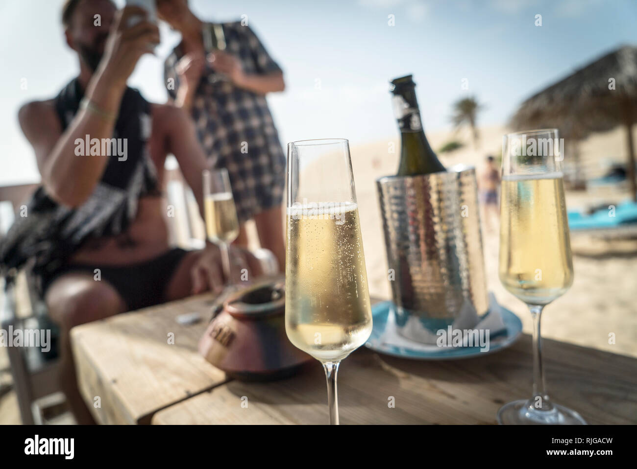 Champagnergläser am Strand, Leute auf Hintergrund Stockfoto