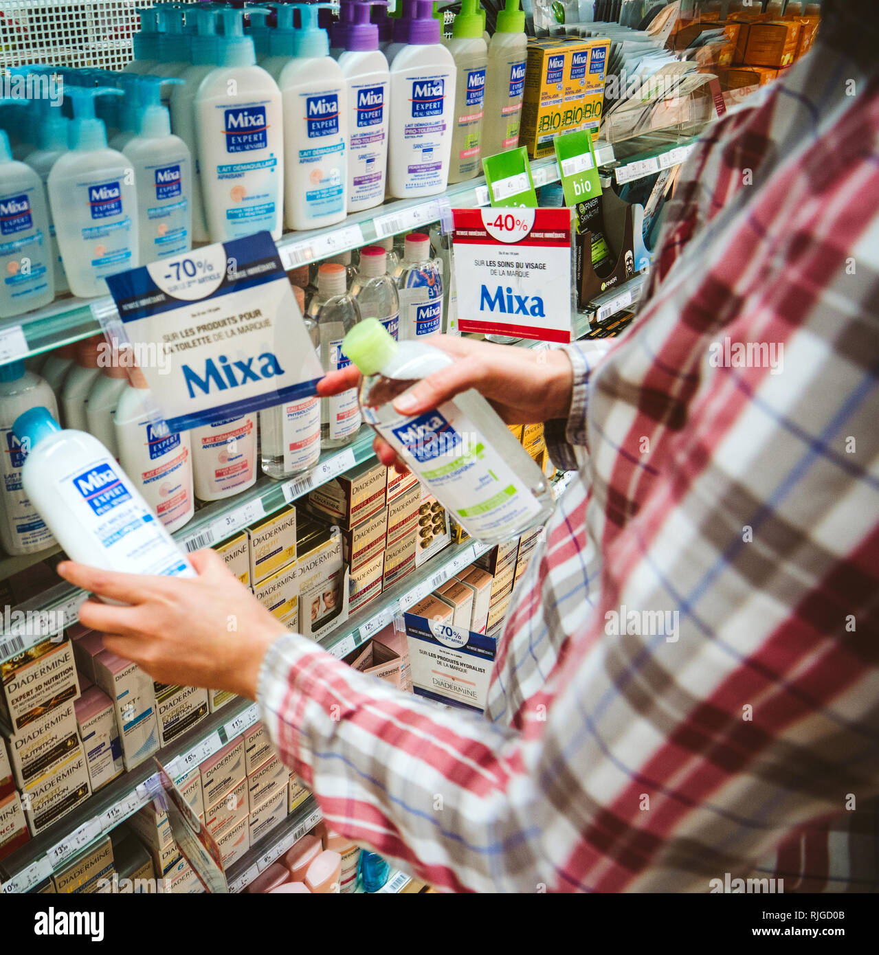 PARIS, Frankreich, 23.Juni, 2018: Frau entscheiden, was zu Shop von Mixa micellares Milch diverse Kosmetika und healthcare medizinische Produkte in Schönheit Apotheke Supermarkt in Frankreich Cicabiafine Stockfoto