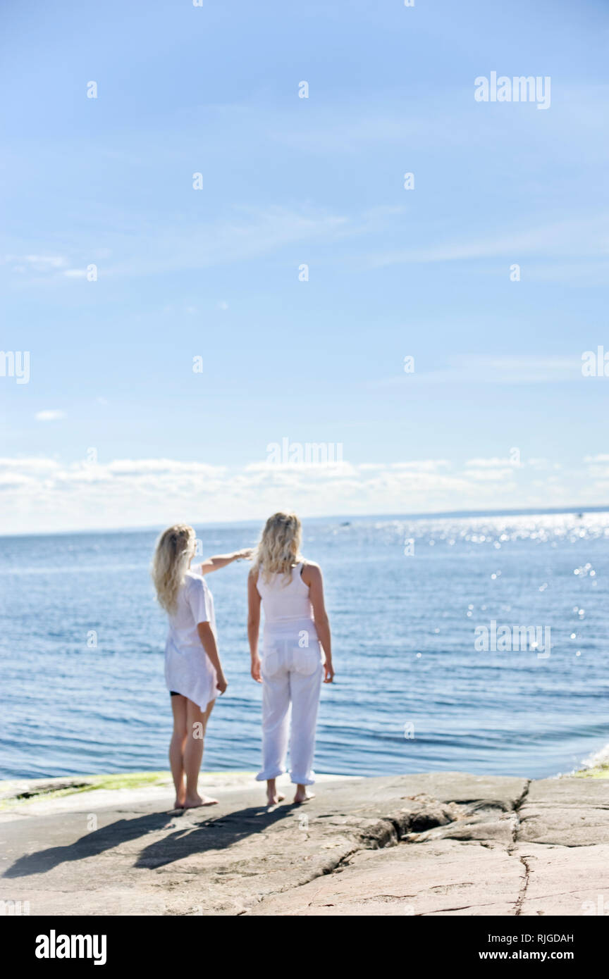 Junge Frauen stehen und auf See Stockfoto