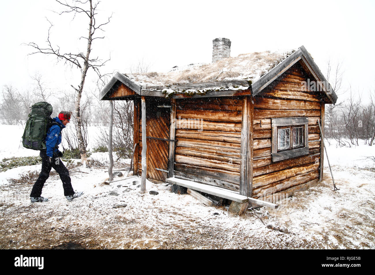 Backpacker in der Nähe von Holz- Haus Stockfoto