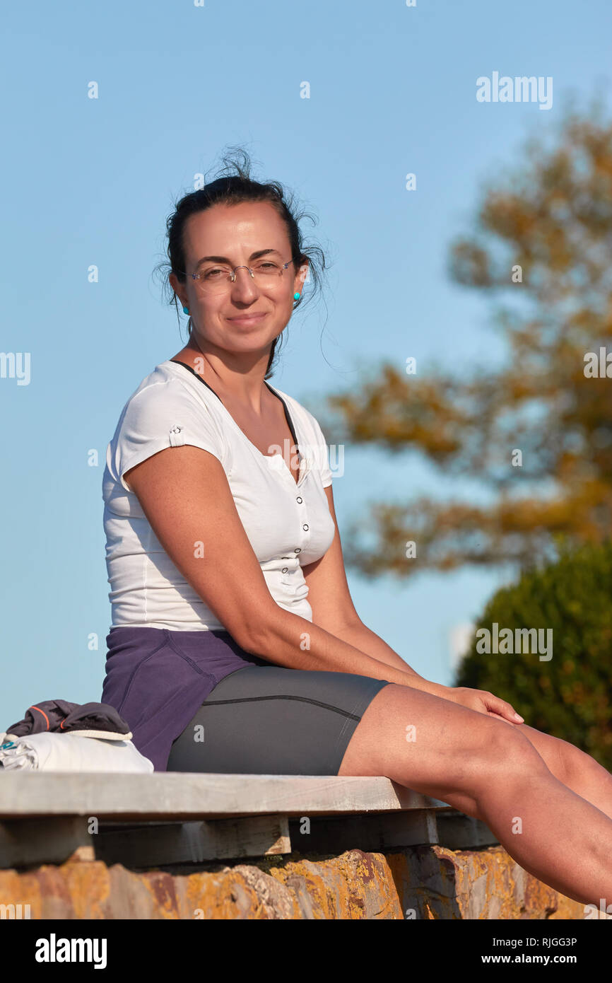 Schöne Spanische Frau auf der Bank sitzen an einem sonnigen Tag Stockfoto