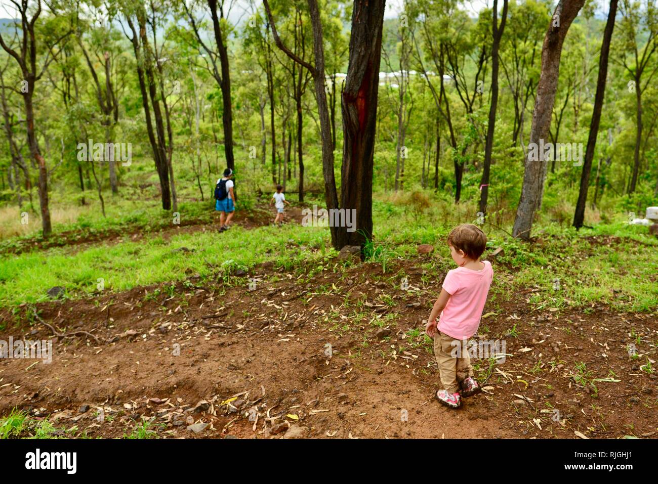 Junge Kinder im Schulalter entlang einem Feldweg, Moongun Wanderweg am Elliot Federn, Townsville, Queensland, Australien Stockfoto