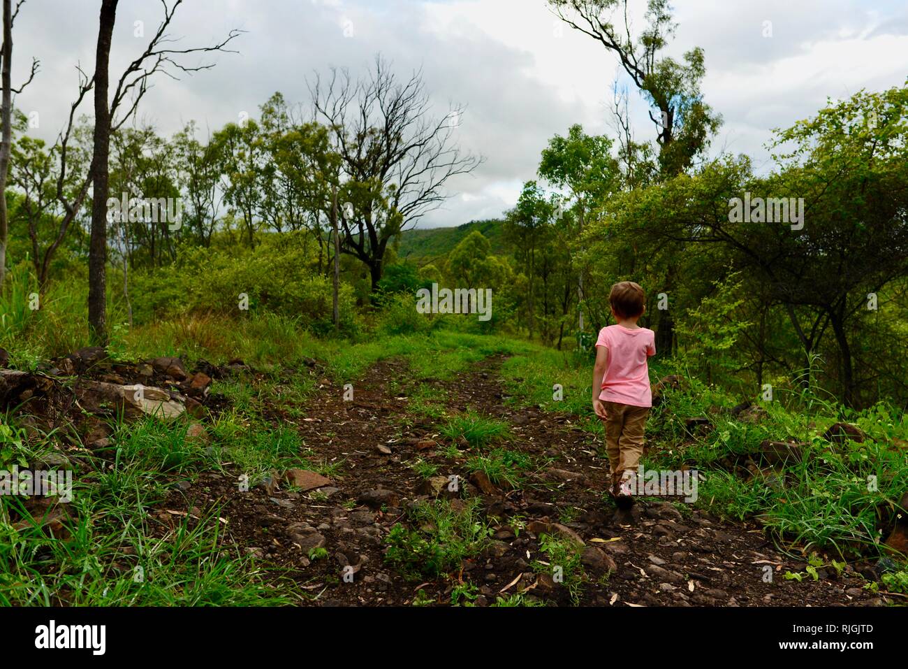 Junge Kinder im Schulalter entlang einem Feldweg, Moongun Wanderweg am Elliot Federn, Townsville, Queensland, Australien Stockfoto