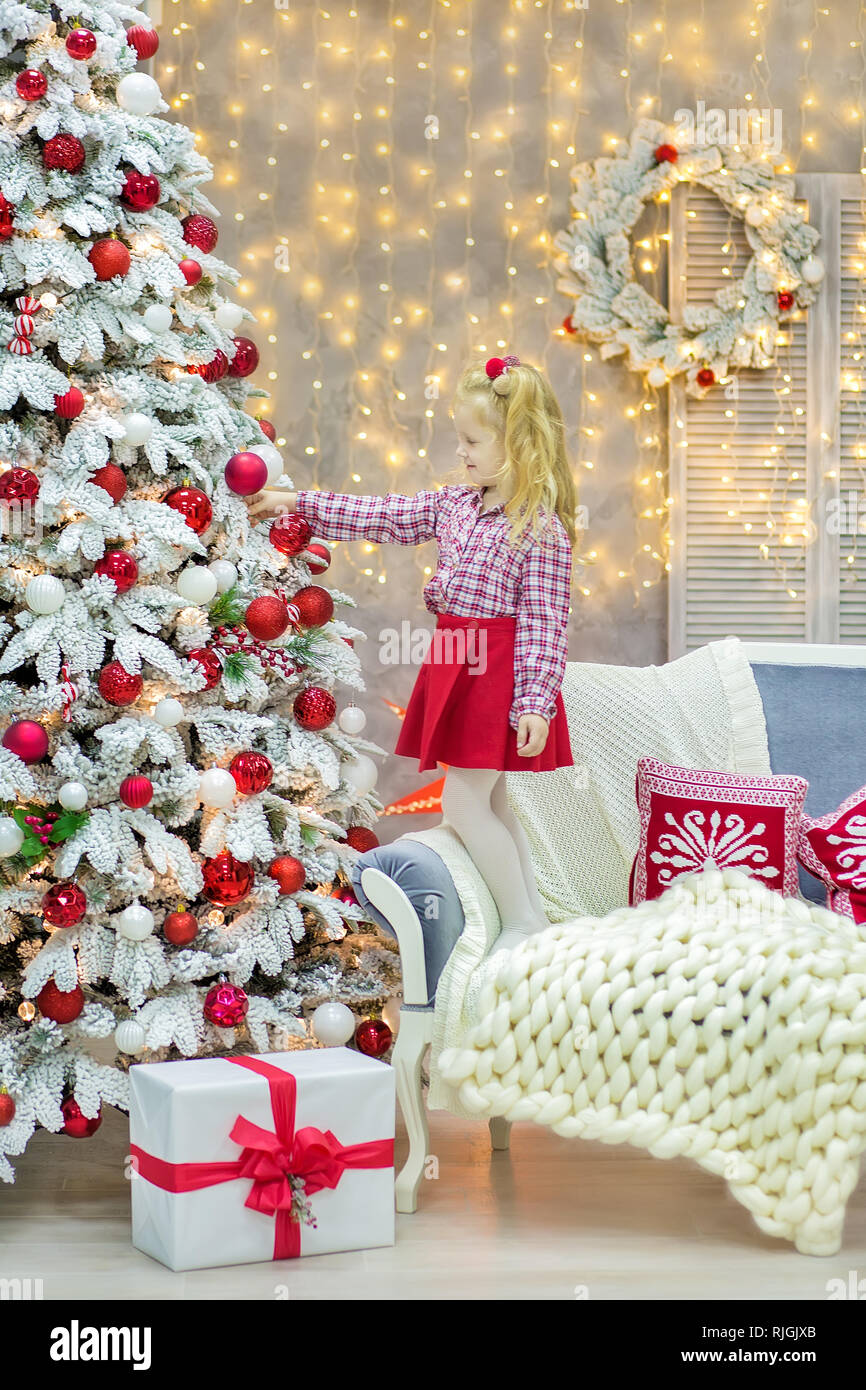 Weihnachten casual Gold studio Dekorationen mit netten Mädchen und Spiegel  mit goldenem Rahmen viel Geschenke und große, grüne Tanne Stockfotografie -  Alamy