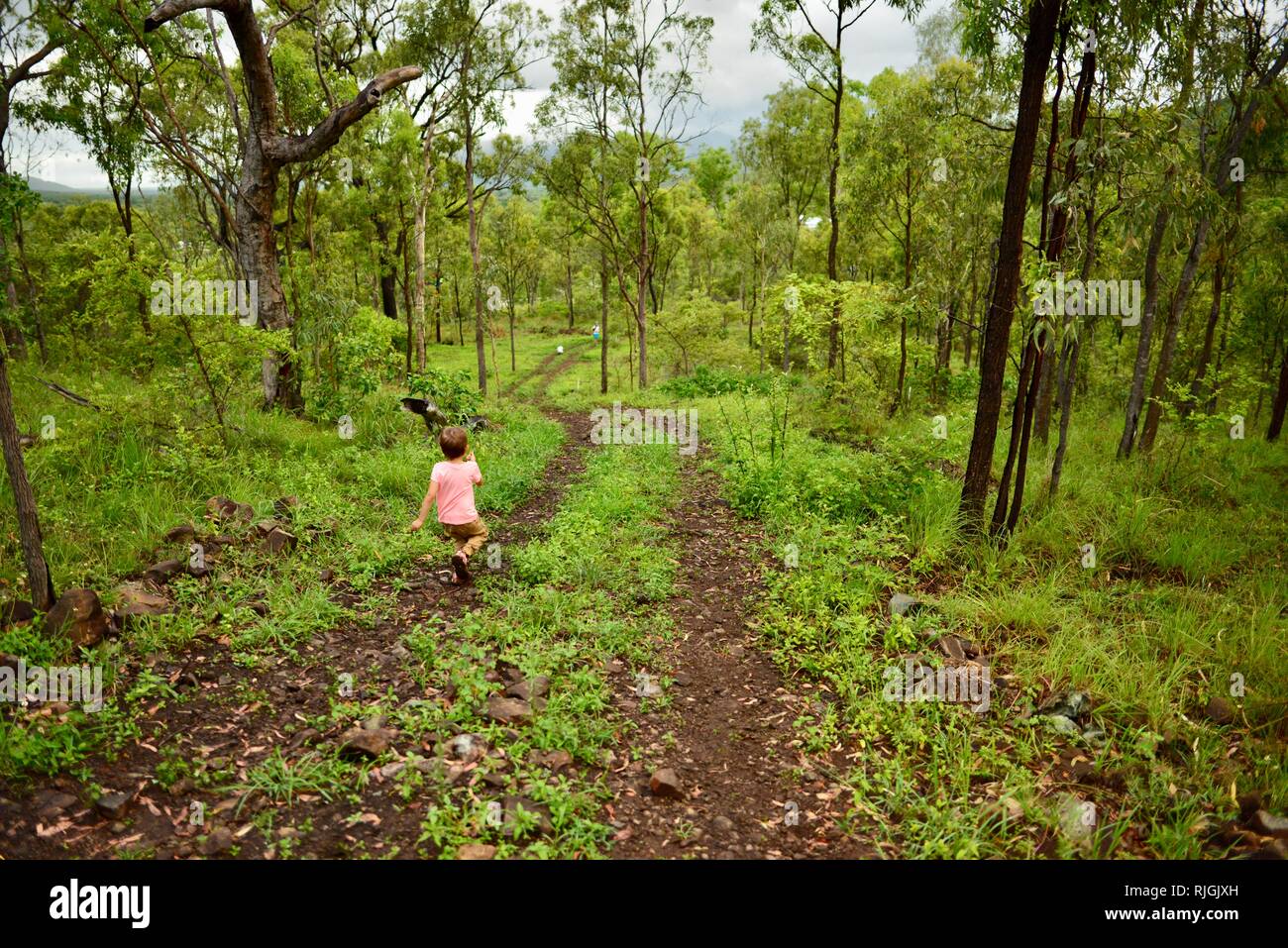 Junge Kinder im Schulalter entlang einem Feldweg, Moongun Wanderweg am Elliot Federn, Townsville, Queensland, Australien Stockfoto