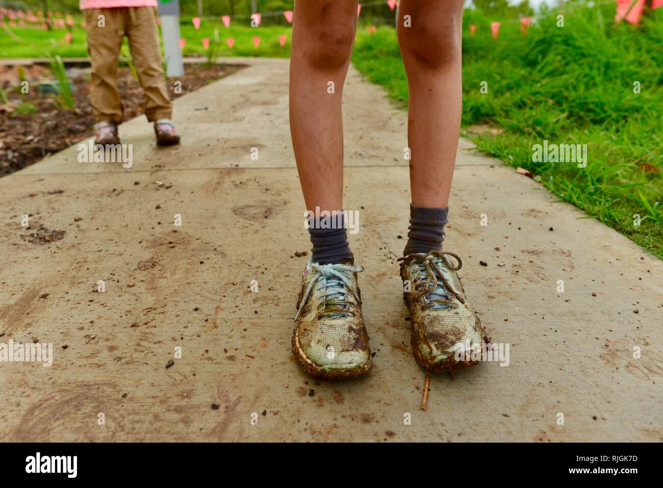 Schlammigen Schuhen auf junge Kinder im schulpflichtigen Alter nach einem Spaziergang entlang einem Feldweg, Moongun Wanderweg am Elliot Federn, Townsville, Queensland, Australien Stockfoto