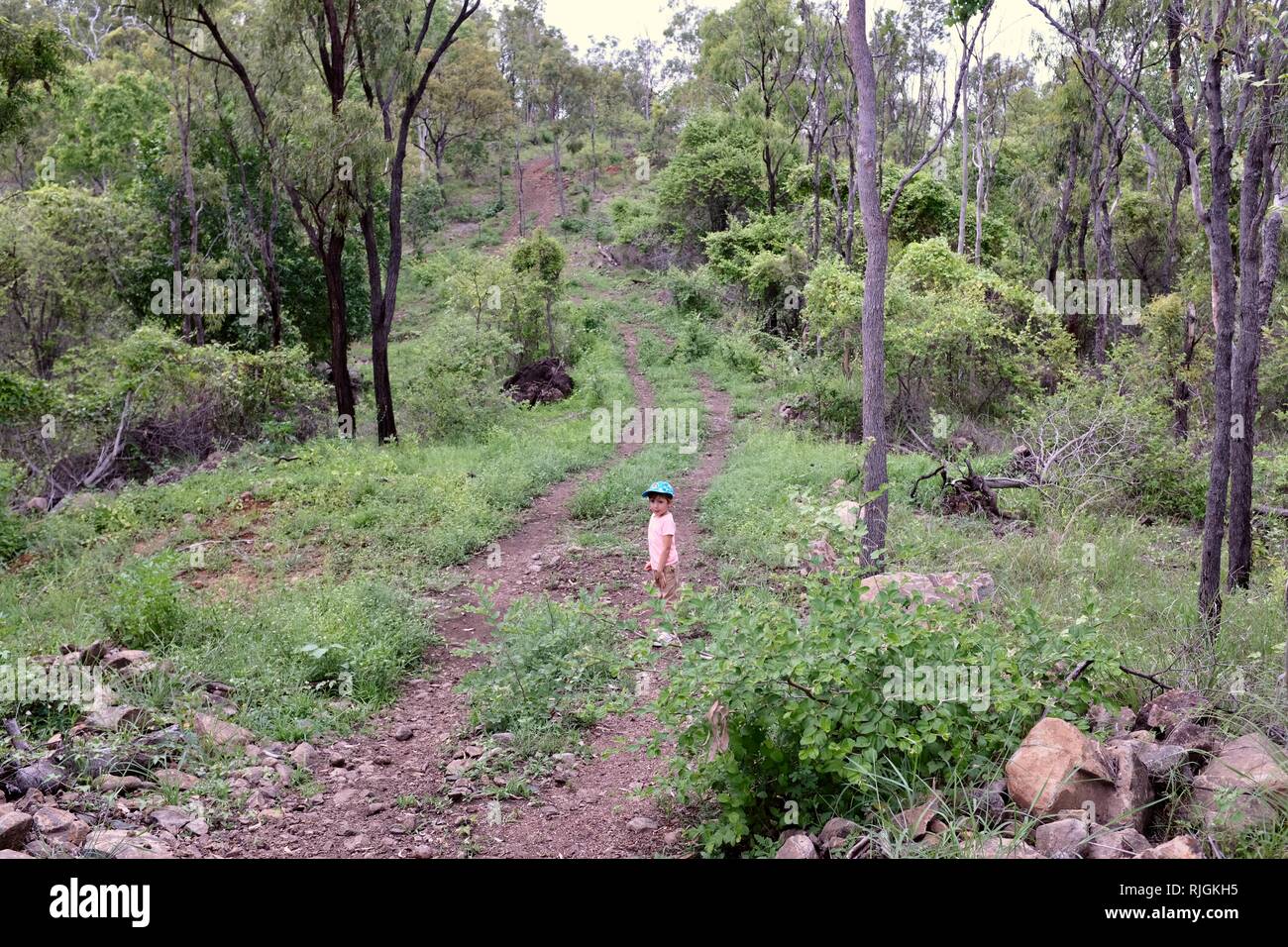 Junge Kinder im Schulalter entlang einem Feldweg, Moongun Wanderweg am Elliot Federn, Townsville, Queensland, Australien Stockfoto