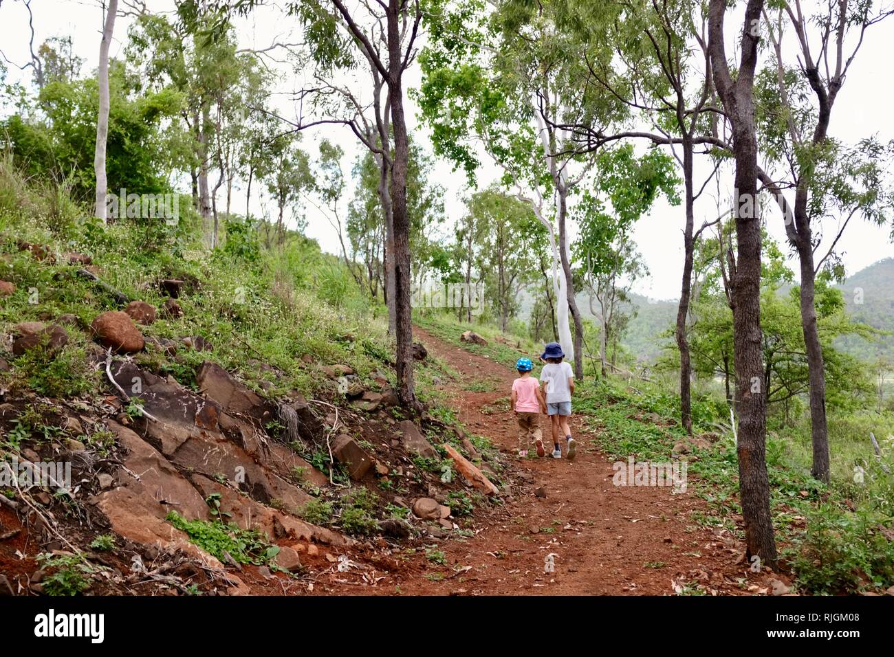 Junge Kinder im Schulalter entlang einem Feldweg, Moongun Wanderweg am Elliot Federn, Townsville, Queensland, Australien Stockfoto