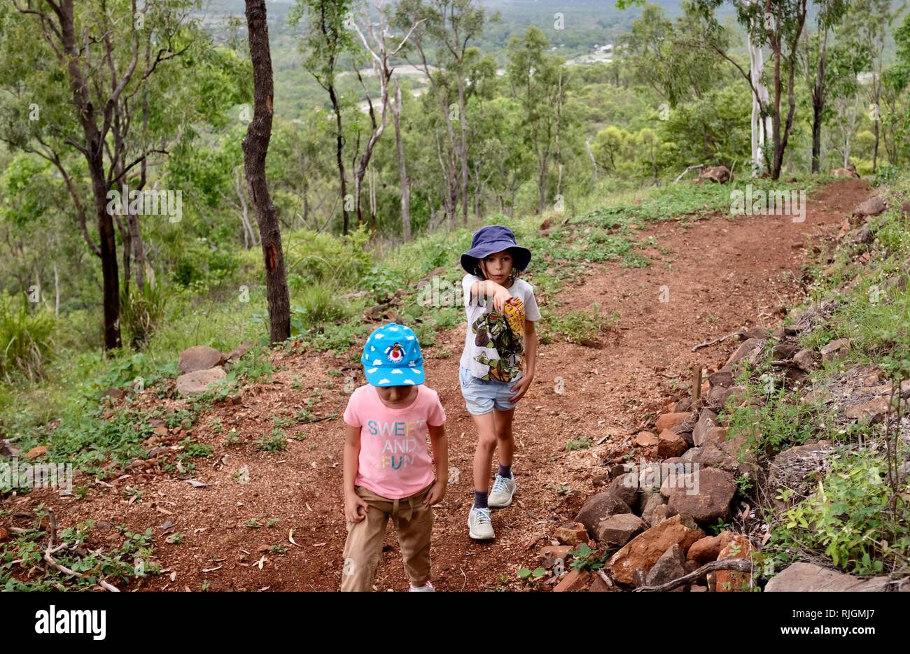 Junge Kinder im Schulalter entlang einem Feldweg, Moongun Wanderweg am Elliot Federn, Townsville, Queensland, Australien Stockfoto