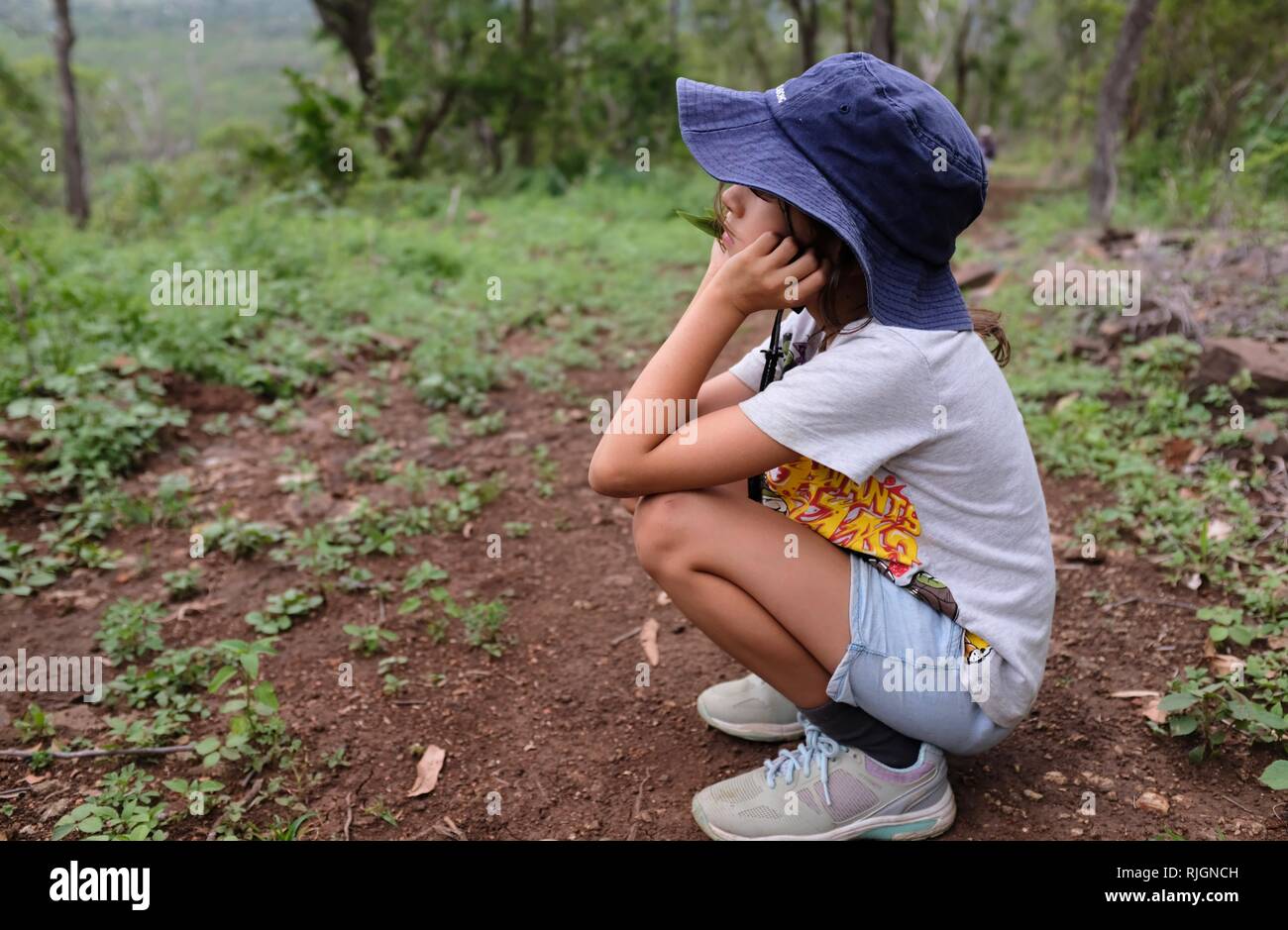 Junge schulpflichtige Mädchen Langweilten oder in der Verzweiflung allein auf einem Feldweg, Moongun Wanderweg am Elliot Federn, Townsville, Queensland, Australien Stockfoto