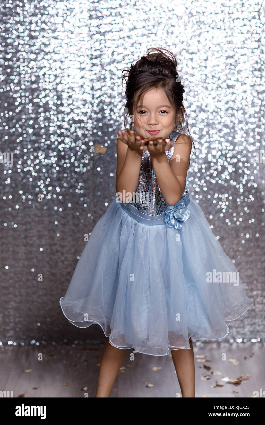 Schöne glückliche kleine Kind Mädchen in Blau prinzessin kleid mit Konfetti  auf Hintergrund mit Silber bokeh. Geburtsdatum Partei Stockfotografie -  Alamy
