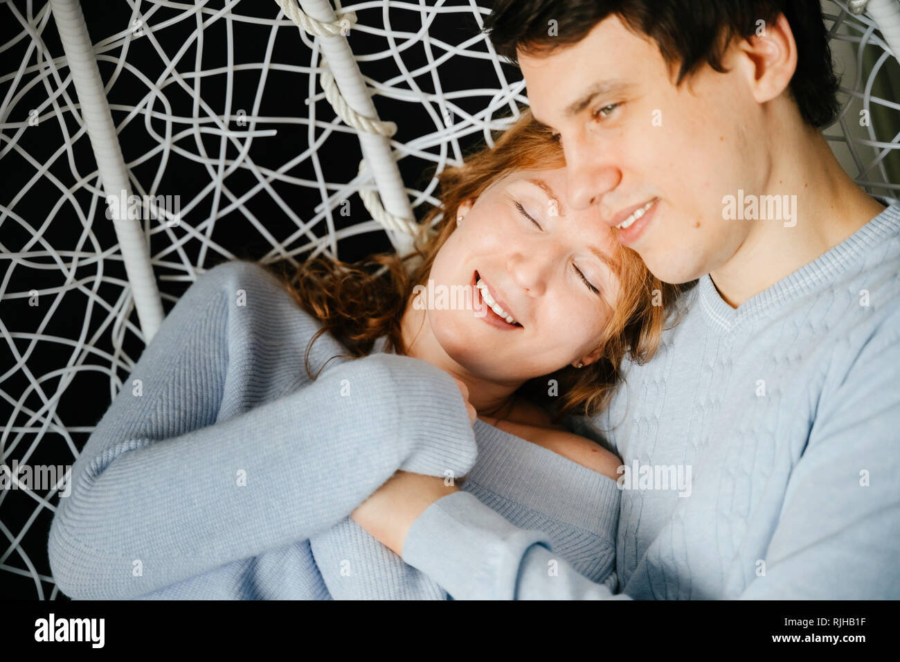 Paar Mädchen und Guy umarmen auf einem grossen Stuhl. Stockfoto