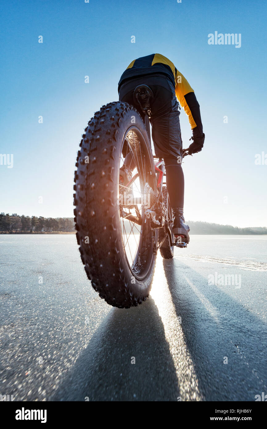 Man Radfahren auf einem zugefrorenen See Stockfoto