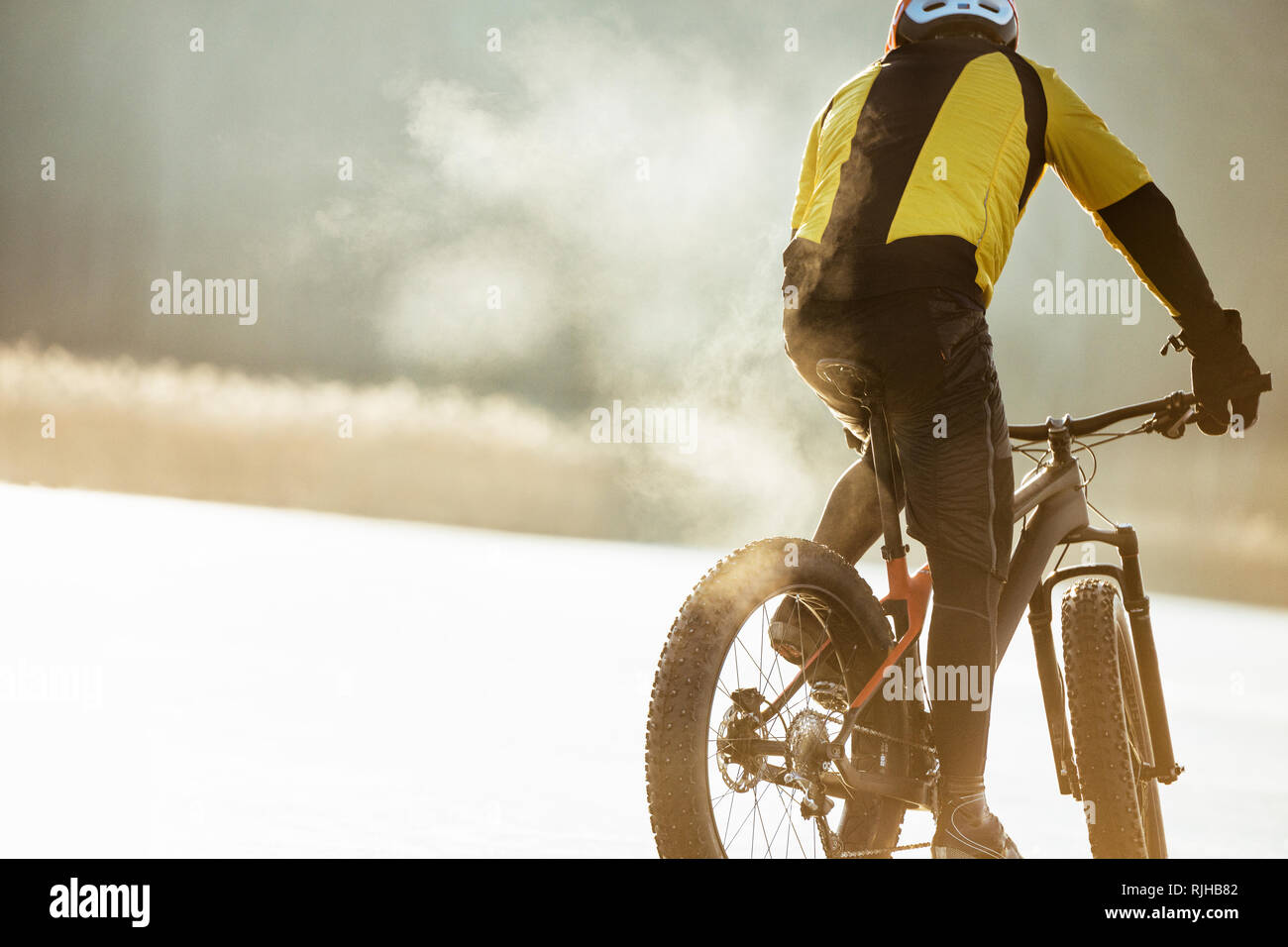 Man Radfahren auf einem zugefrorenen See Stockfoto