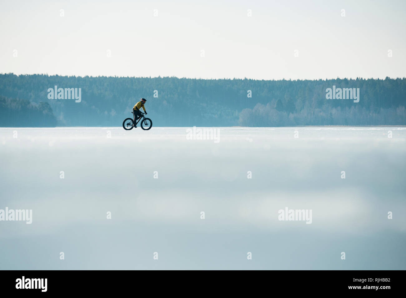 Man Radfahren auf einem zugefrorenen See Stockfoto