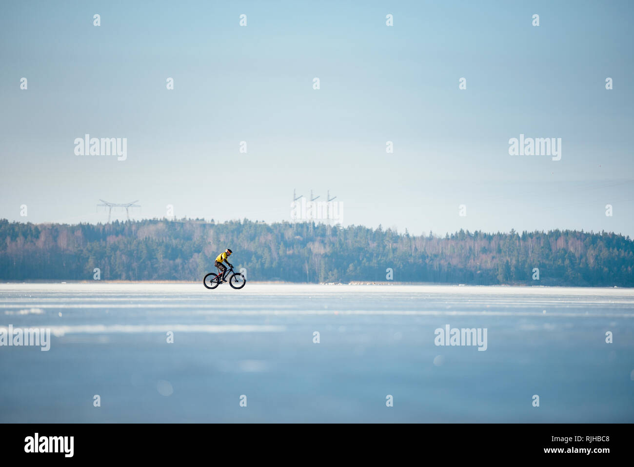 Man Radfahren auf einem zugefrorenen See Stockfoto