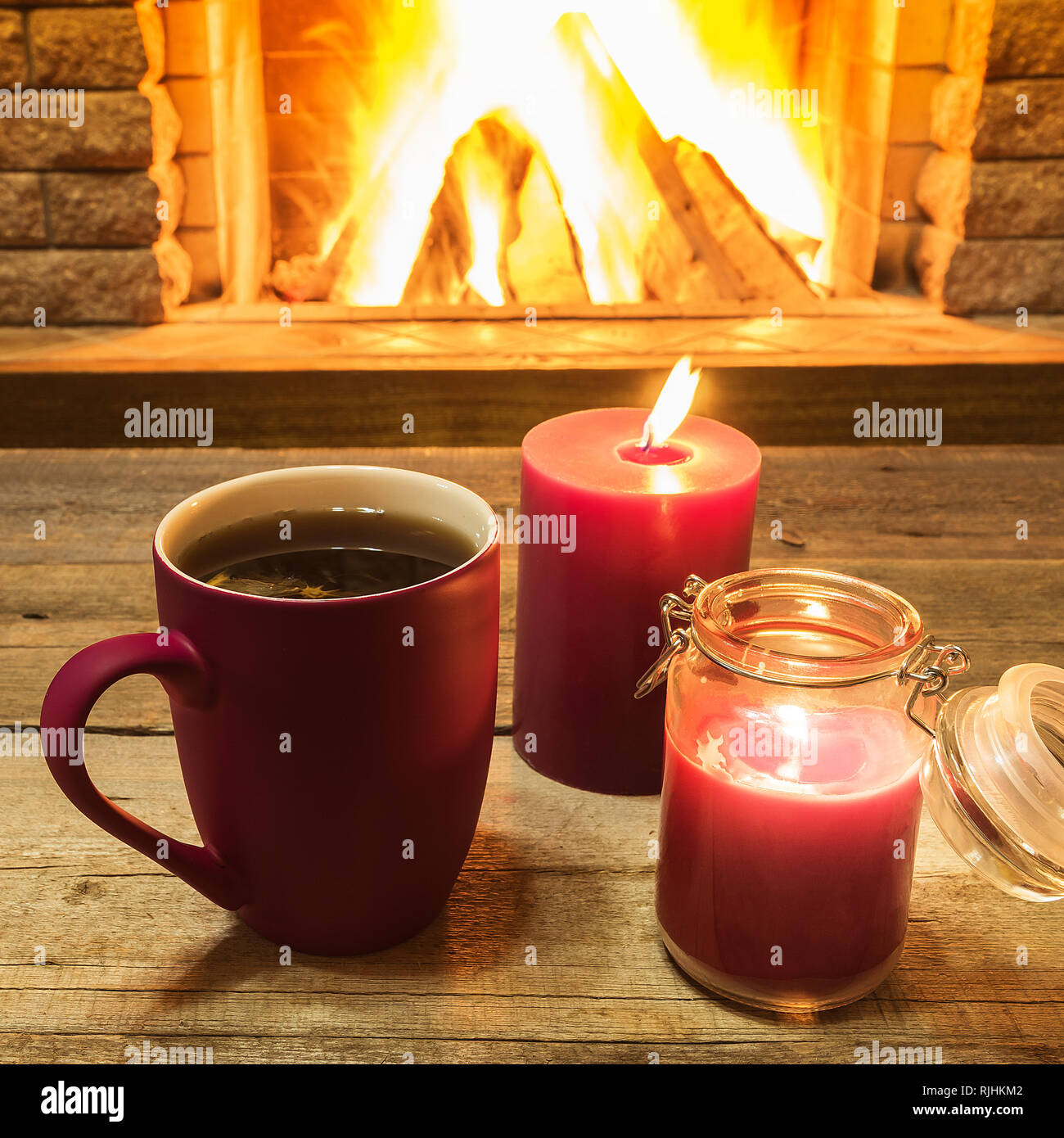 Becher mit heißem Tee und Kerzen in der Nähe der gemütlichen Kamin, im  Landhaus, Winter Urlaub Stockfotografie - Alamy