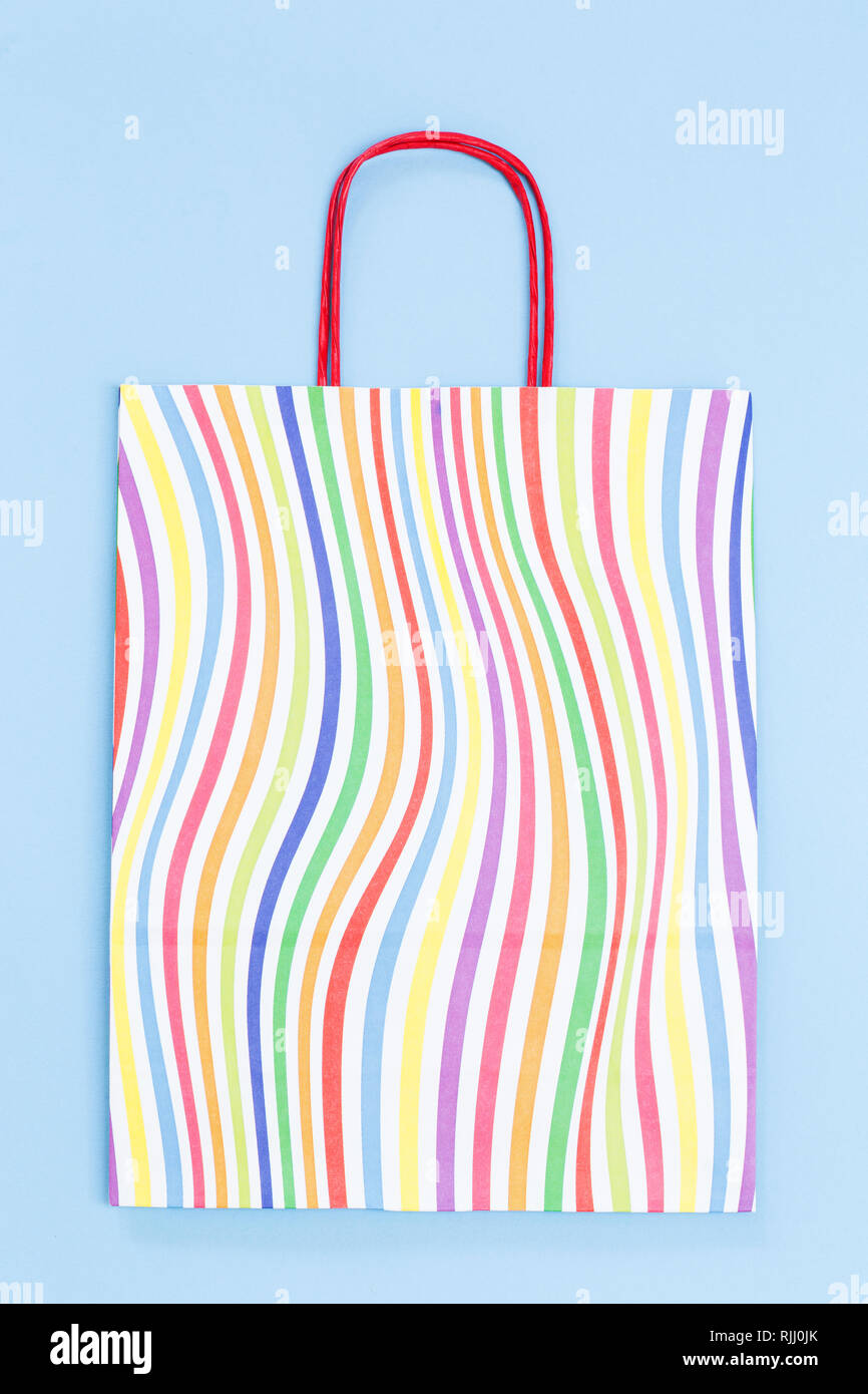 Bunte Papierbeutel auf blauem Hintergrund Stockfoto