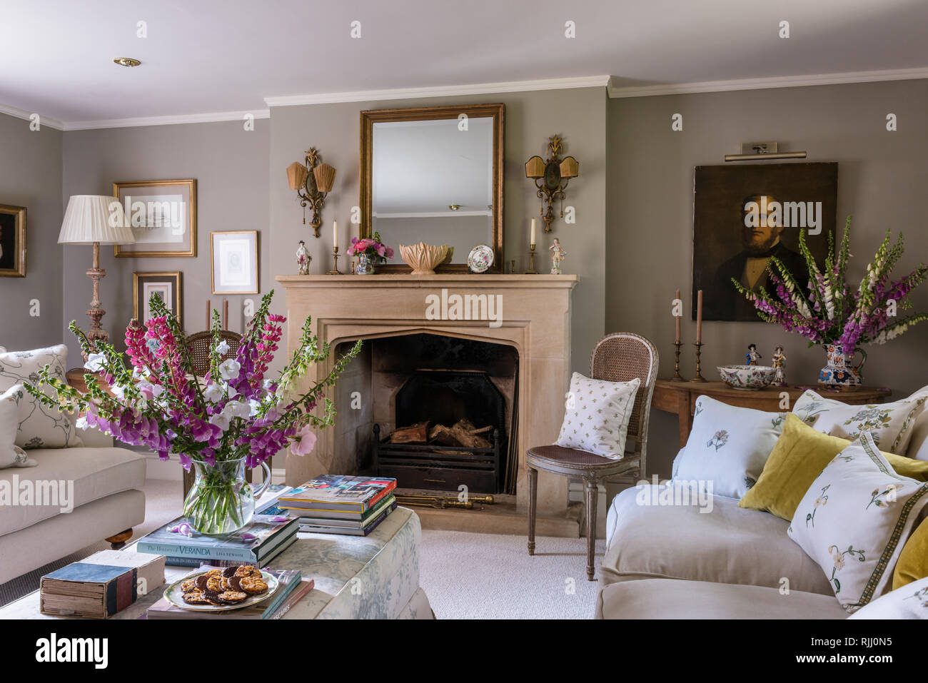 Frische Blumen in Wohnzimmer mit Kamin aus Kalkstein Stockfoto