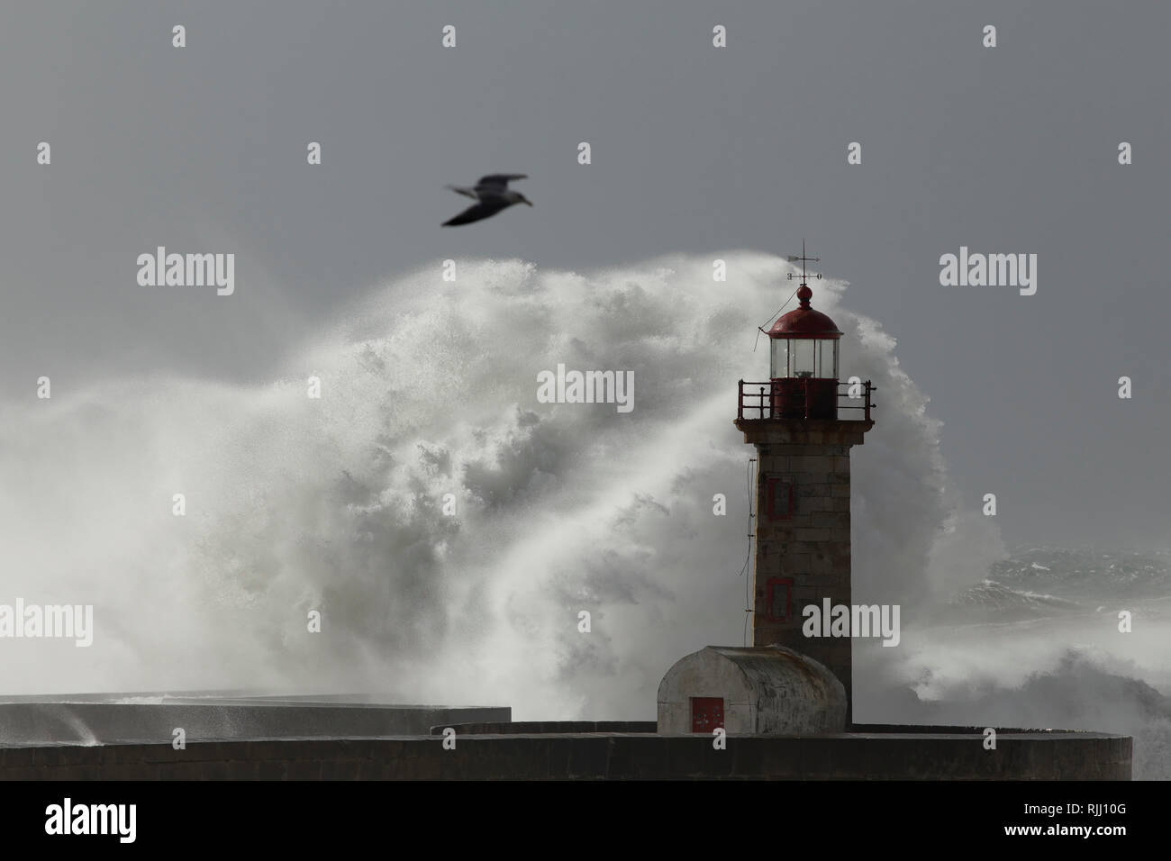 Weiche baclit Big Wave splash. Alte Douro River Mouth Leuchtturm und Pier. Stockfoto