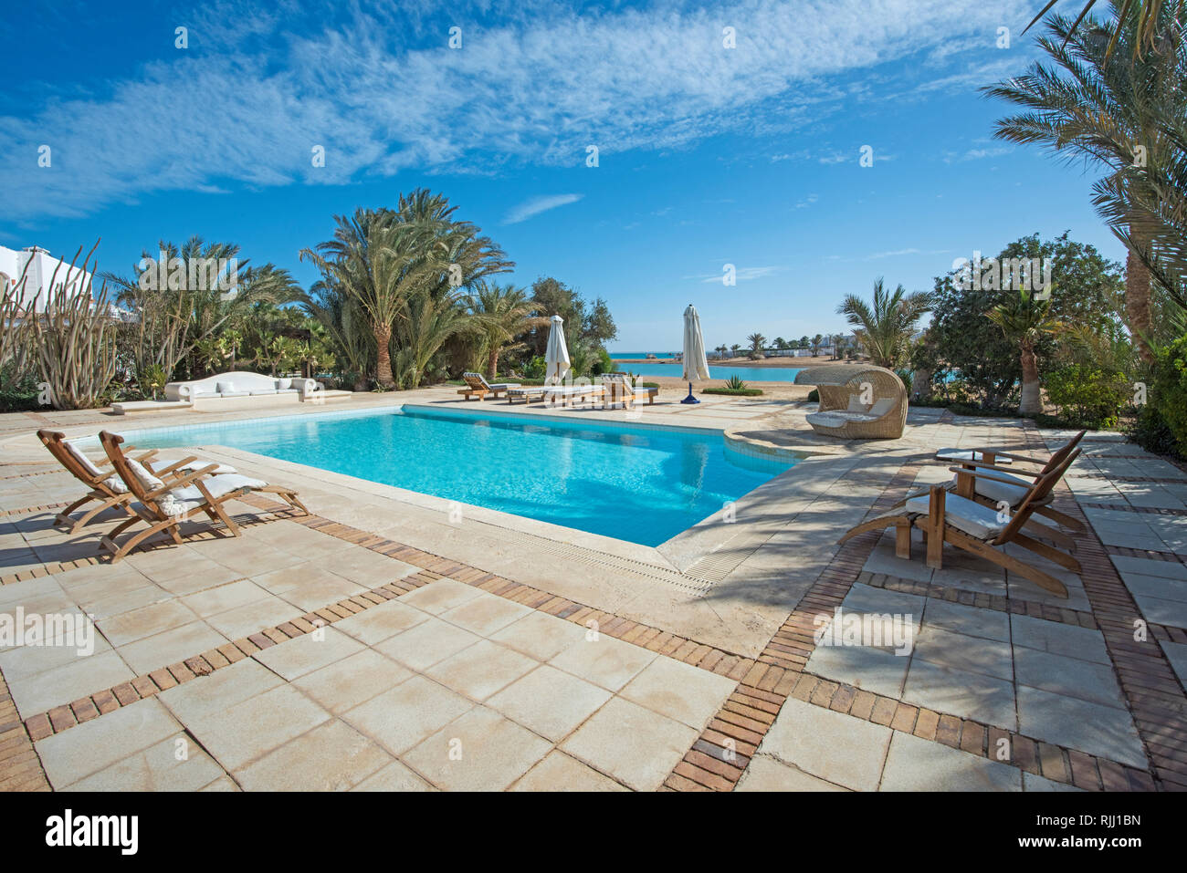 Luxus Villa zeigen Home im tropischen Sommer Holiday Resort mit Swimmingpool und Liegestühlen Stockfoto