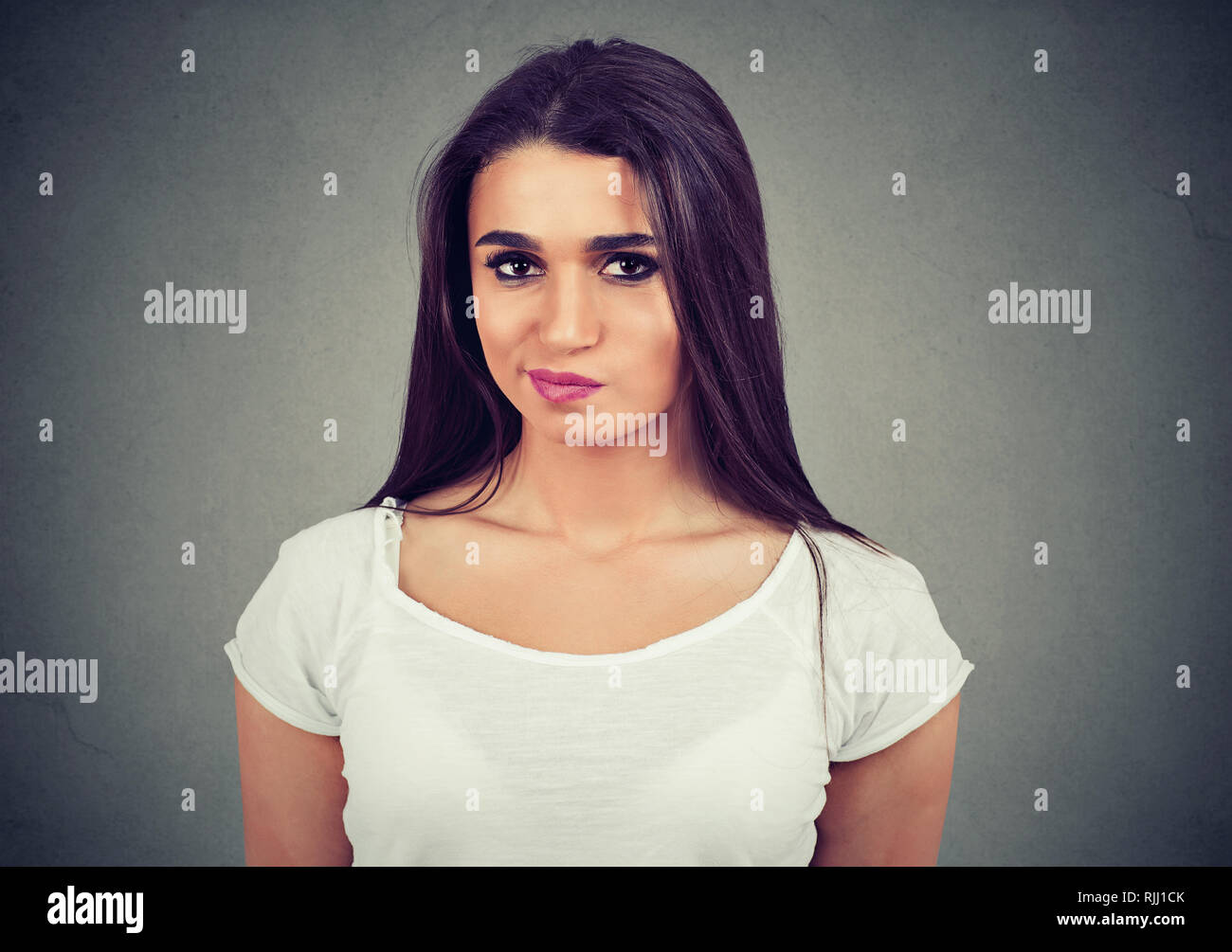 Porträt eines umgekippten Junge casual stehende Frau suchen Missfallen über grauer Hintergrund Stockfoto