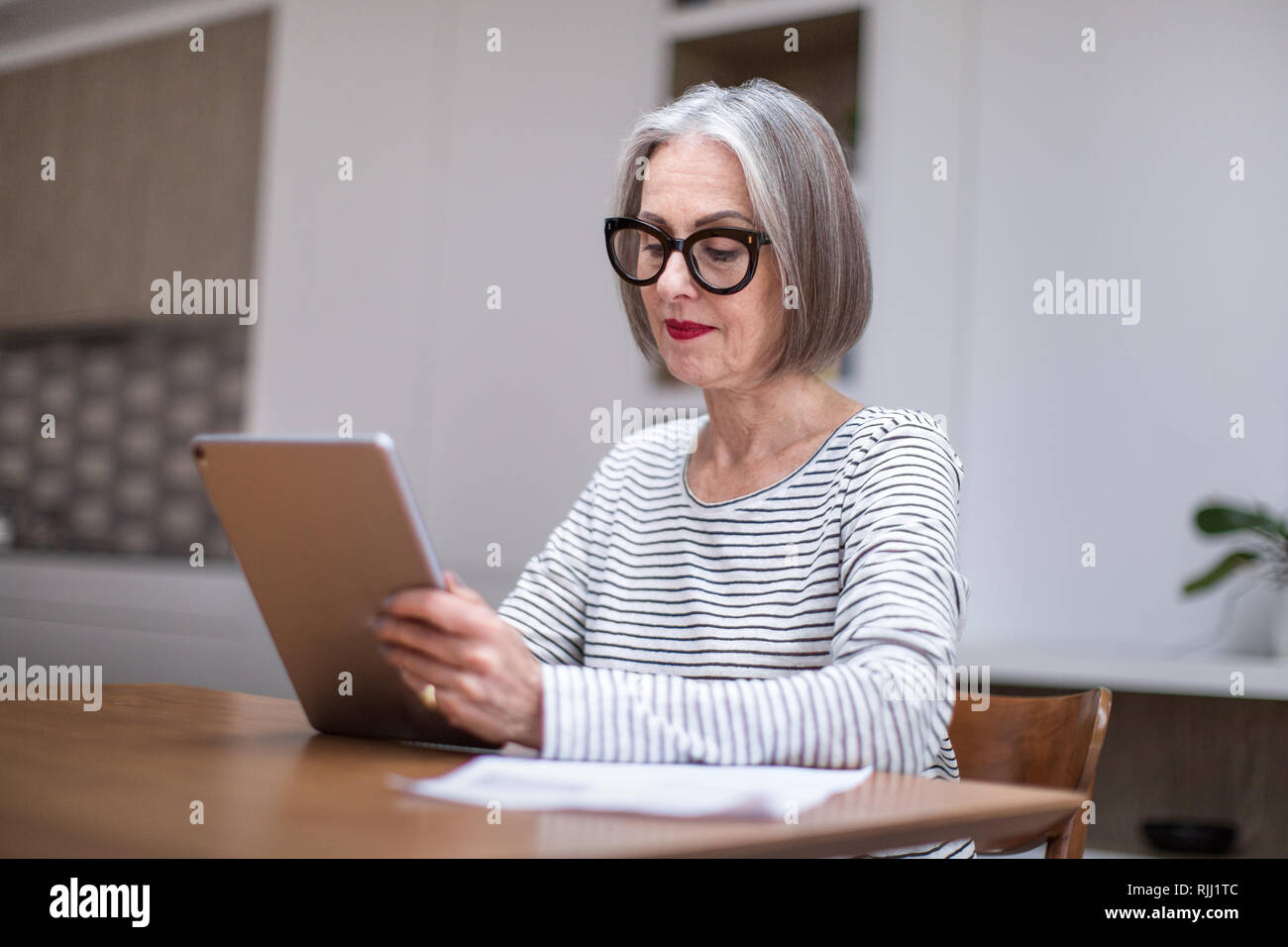 Reifen erwachsenen weiblichen bezahlen Rechnung online mit Hilfe eines digitalen Tablet Stockfoto