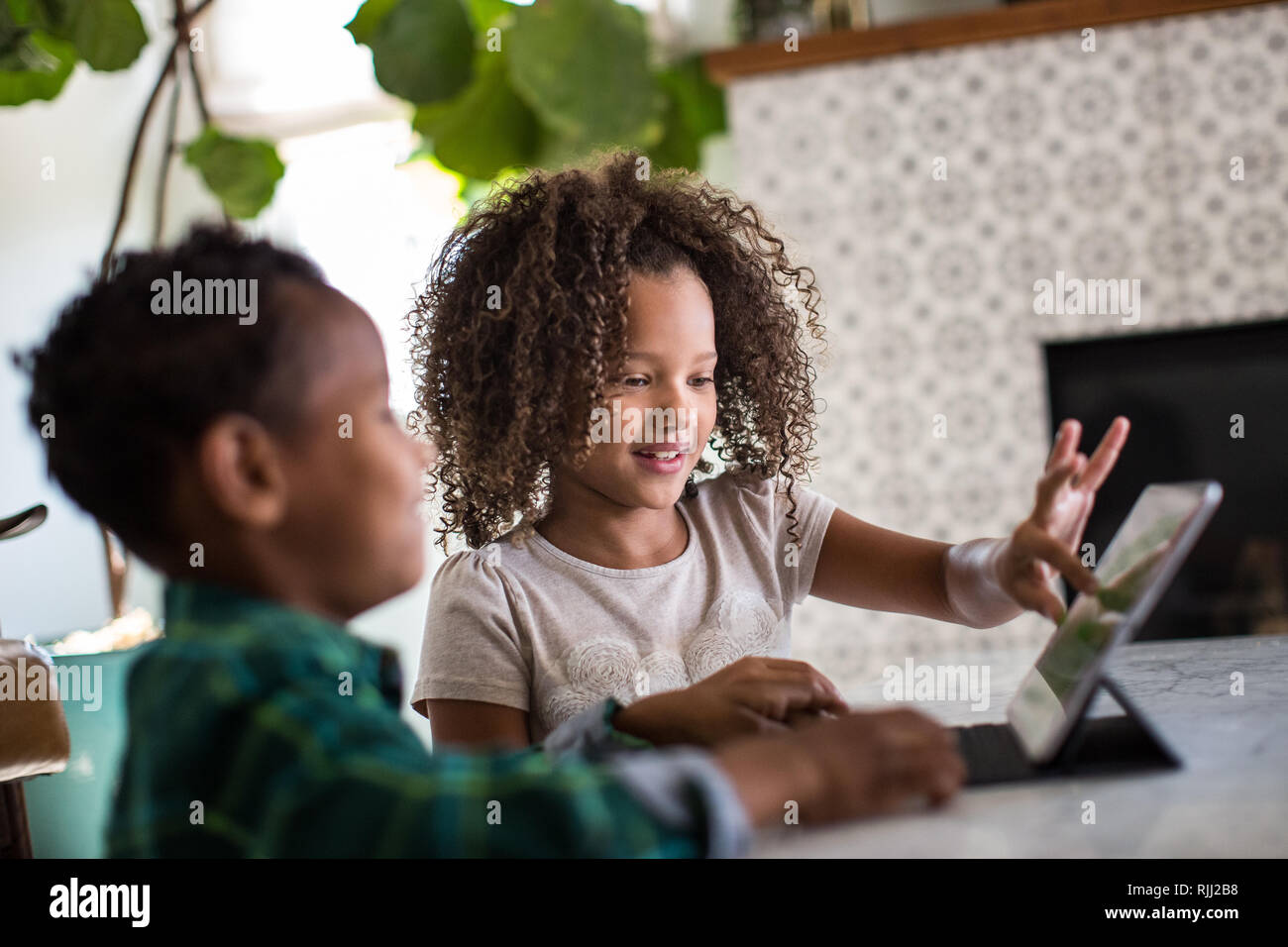 Afrikanische amerikanische Bruder und Schwester spielen zusammen auf digital Tablet Stockfoto
