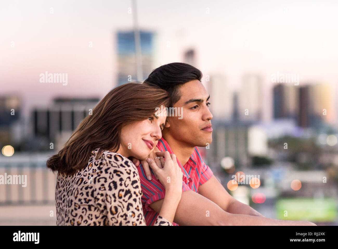 Junge erwachsene Paare mit Blick über die Skyline der Stadt Stockfoto