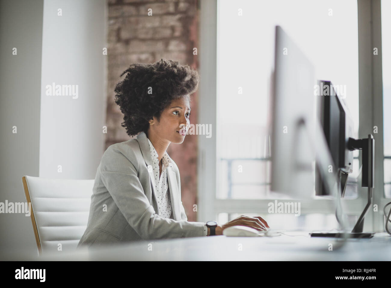 Weibliche african american Business Executive die Arbeit in einem Büro auf einem Desktop-Computer Stockfoto