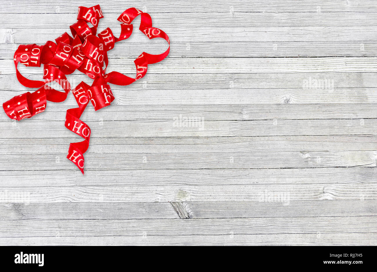 Curly red christmas Band auf Grau rustikal im Alter von Holz Stockfoto