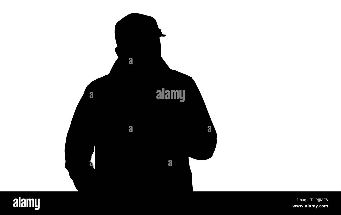 Silhouette einer positiven bärtigen Mann in einem Trenchcoat gekleidet gehen und sprechen. Stockfoto