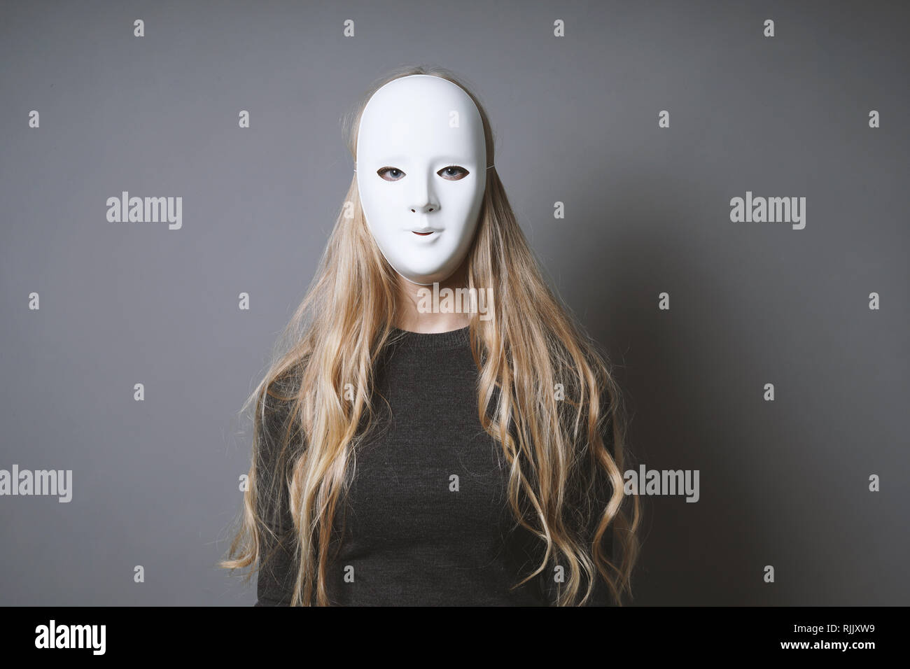 Geheimnisvolle Frau verstecken Gesicht und Identität hinter der Maske Stockfoto