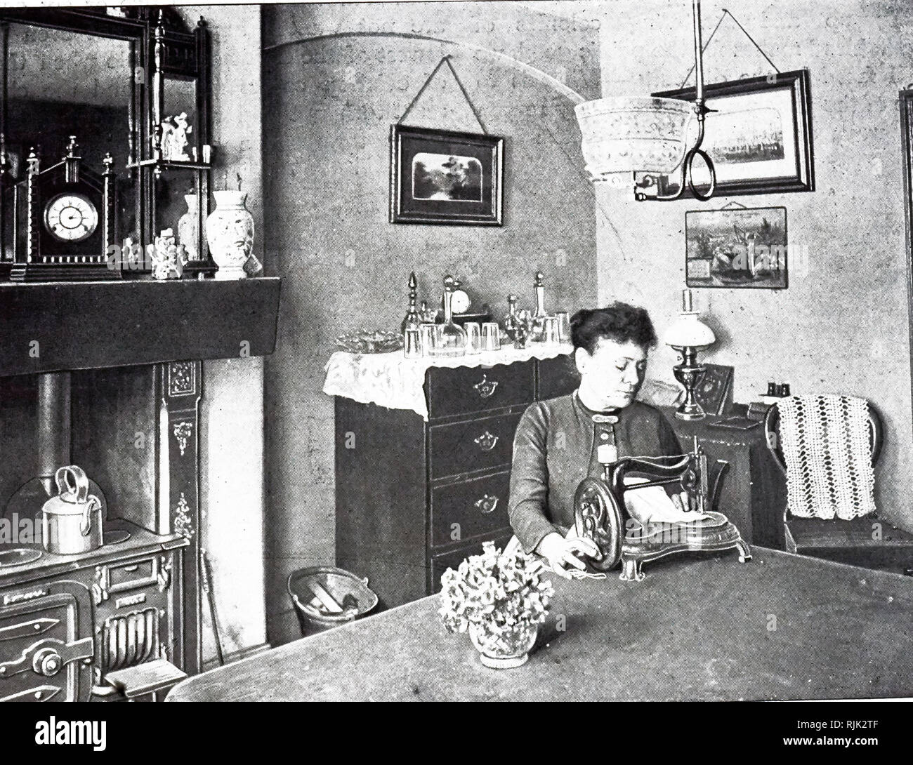 Ein Foto einer Frau mit der Nähmaschine im neuen Zimmer von Ihrem Modell Wohnung. Vom 19. Jahrhundert Stockfoto