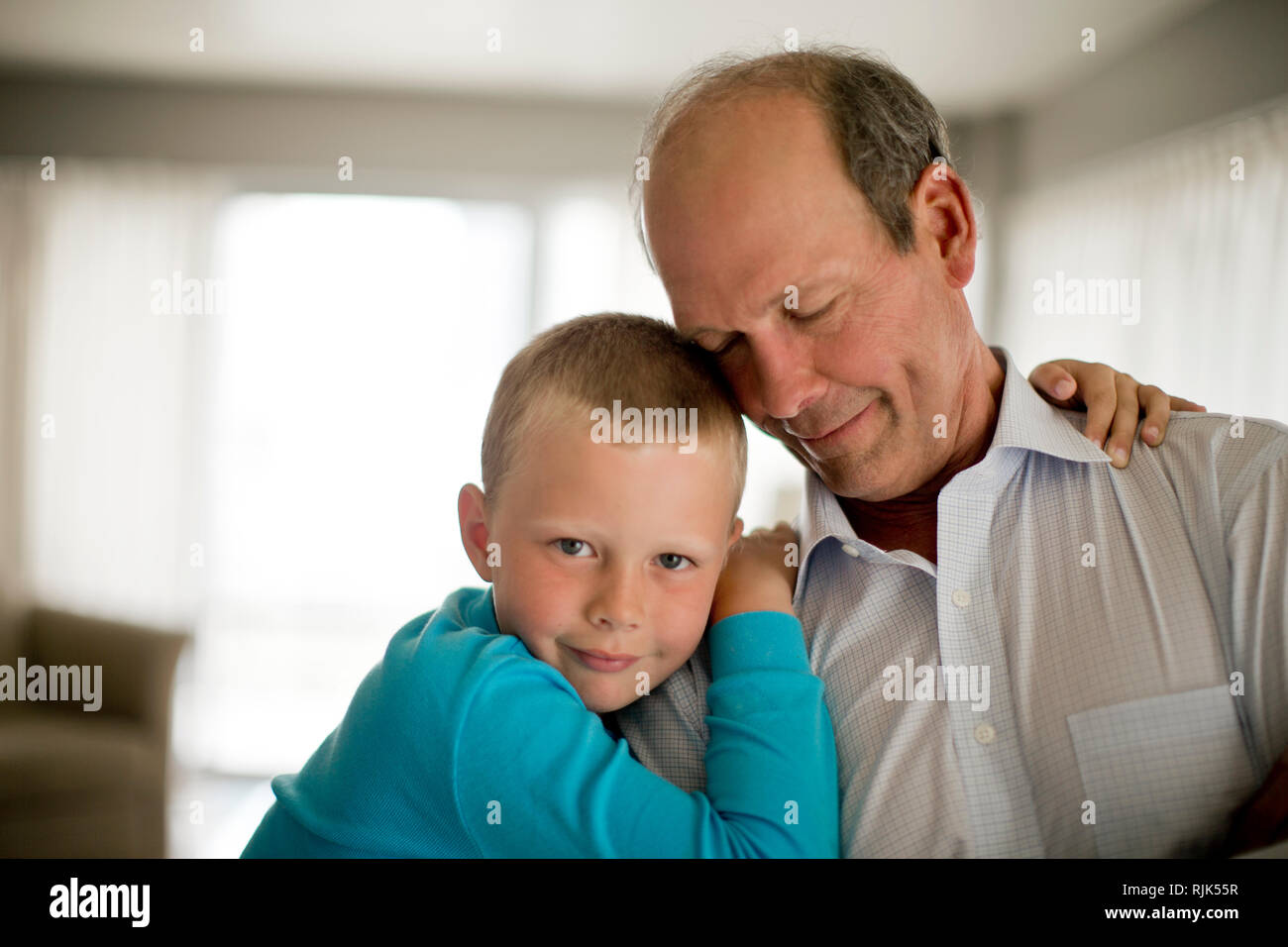 Portrait eines glücklichen jungen Jungen mit seine Arme um seinen Großvater. Stockfoto