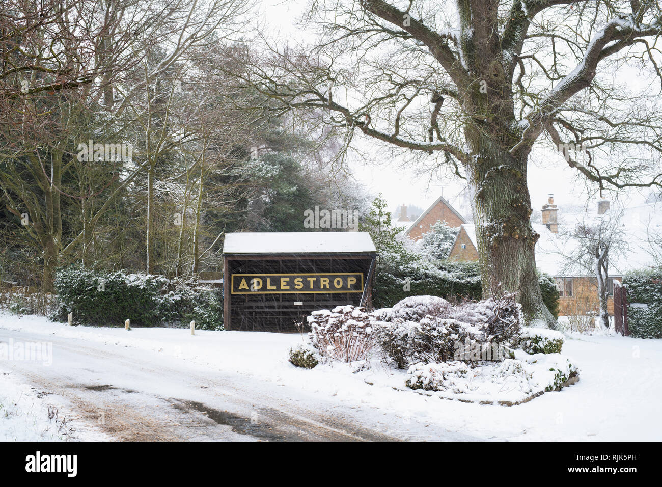 Adlestrop Ortsschild und Bushaltestelle im Winter Schnee. Adlestrop, Cotswolds, Gloucestershire, England Stockfoto