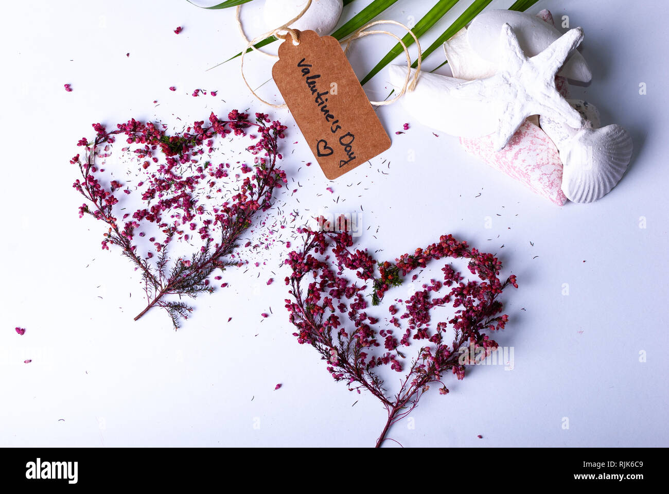 Tow Herzen aus bunten Filialen und ein Etikett mit der Aufschrift "Valentinstag" auf weißem Hintergrund Stockfoto