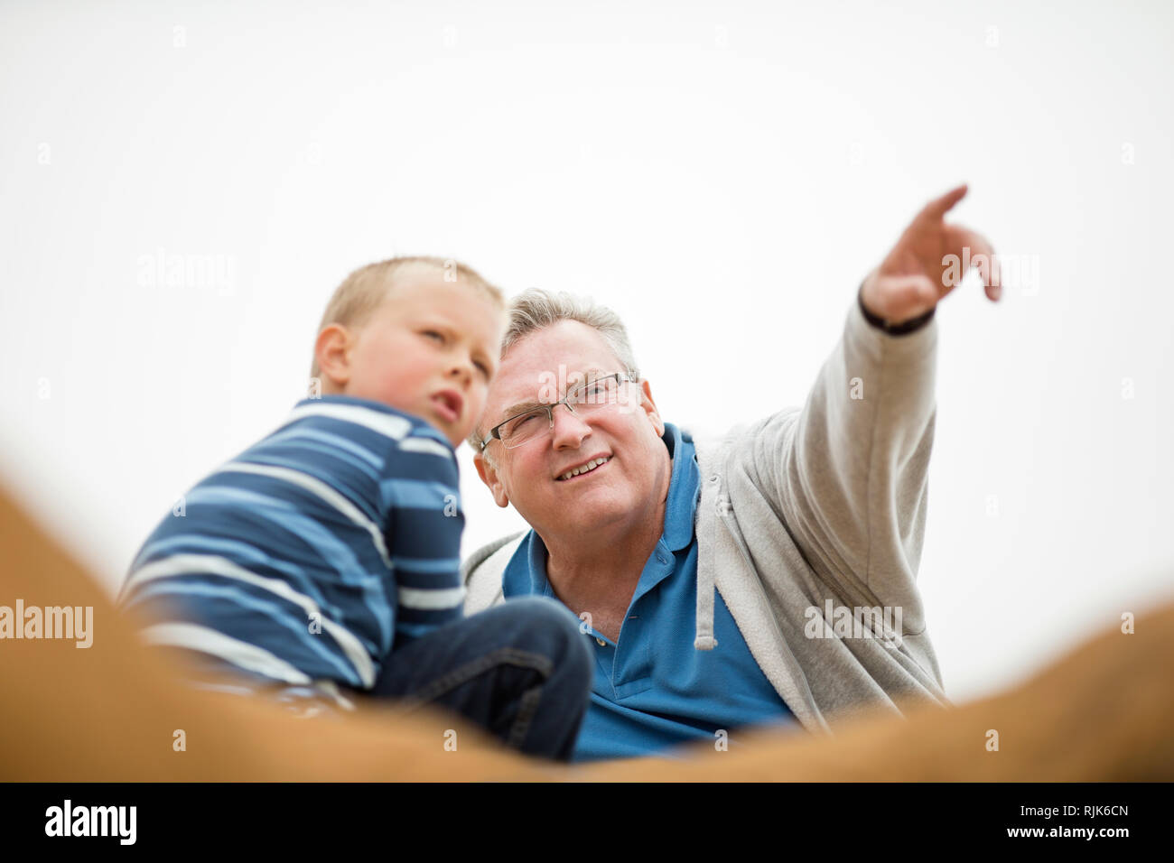 Lächelnd reifer Mann etwas auf seine jungen Enkel. Stockfoto
