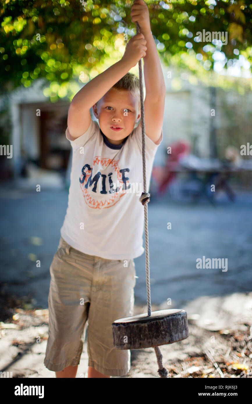 Porträt eines Jungen spielen auf einem Seil schwingen. Stockfoto