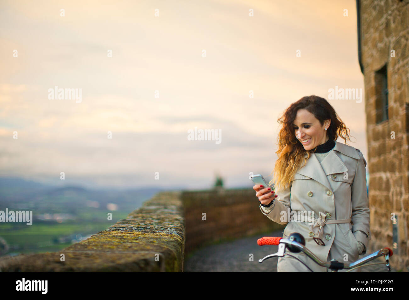 Junge Frau auf dem Fahrrad mit Ihrem Telefon. Stockfoto
