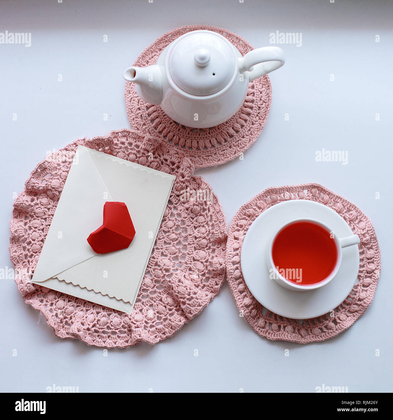 Tasse duftenden rosa Tee auf Häkeln Serviette, Teekanne und Umschlag auf  der Fensterbank. Valentines Tag. Romantik Guten Morgen Stockfotografie -  Alamy