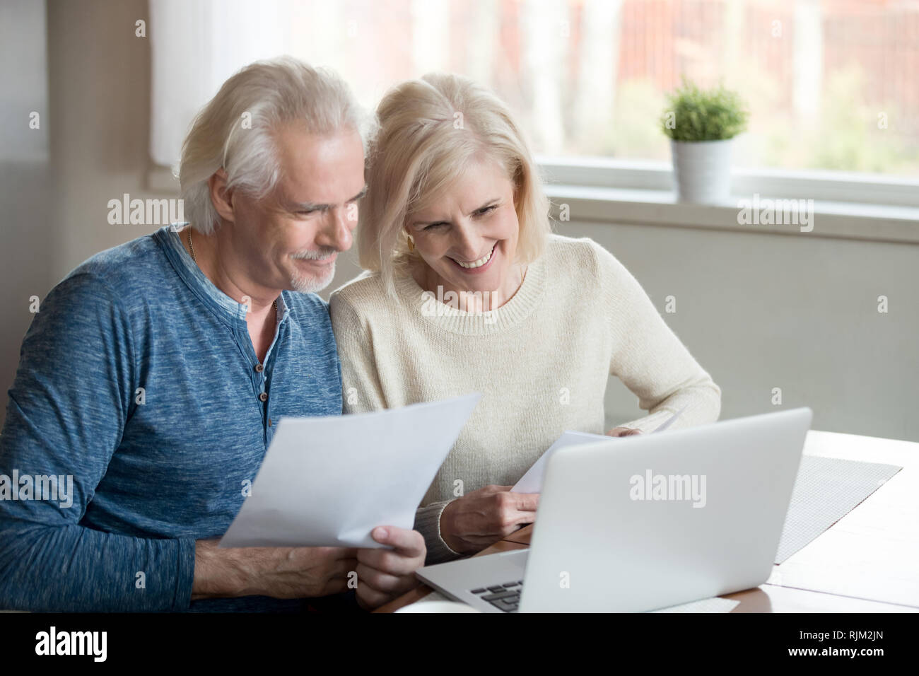 Zufriedene Rentner Ehegatten fühlt sich glücklich erhielt gute Nachrichten von der Bank Stockfoto