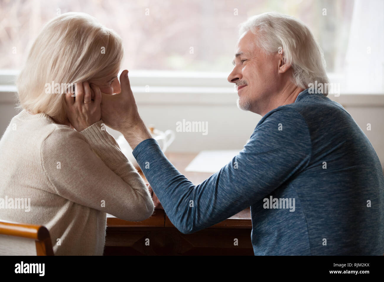 Seitenansicht alter Mann berühren streicheln Antlitz der geliebten Frau Stockfoto