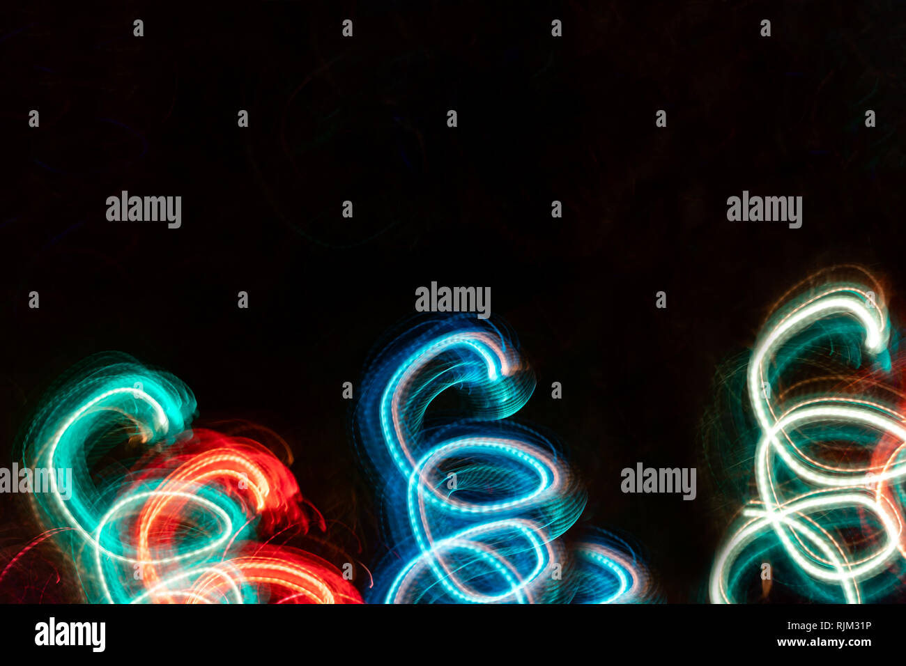 Close-up glühenden Federn auf schwarzem Hintergrund. Abstrakte Zeichnung. Fotografische Effekt mit langen Belichtungszeit. Stockfoto