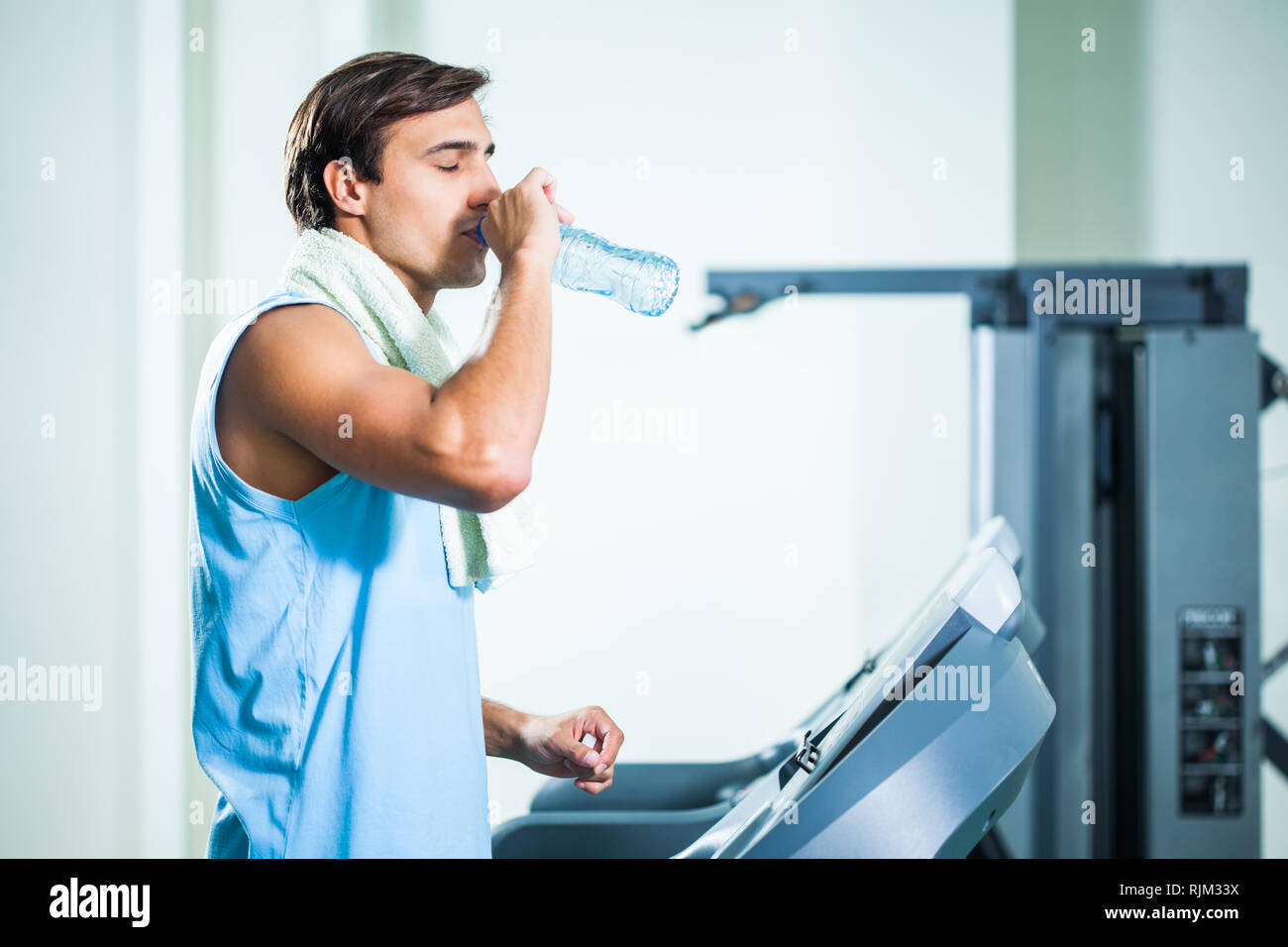 Man Trinkwasser während des Trainings in der Turnhalle Stockfoto